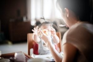 Asian woman feeding an Asian child at home