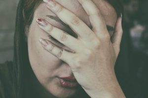 A woman having a headache palms on face